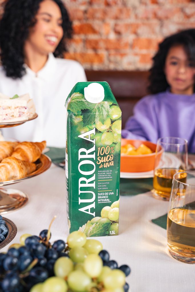 suco de uva aurora na mesa com uma família fazendo lanche da tarde