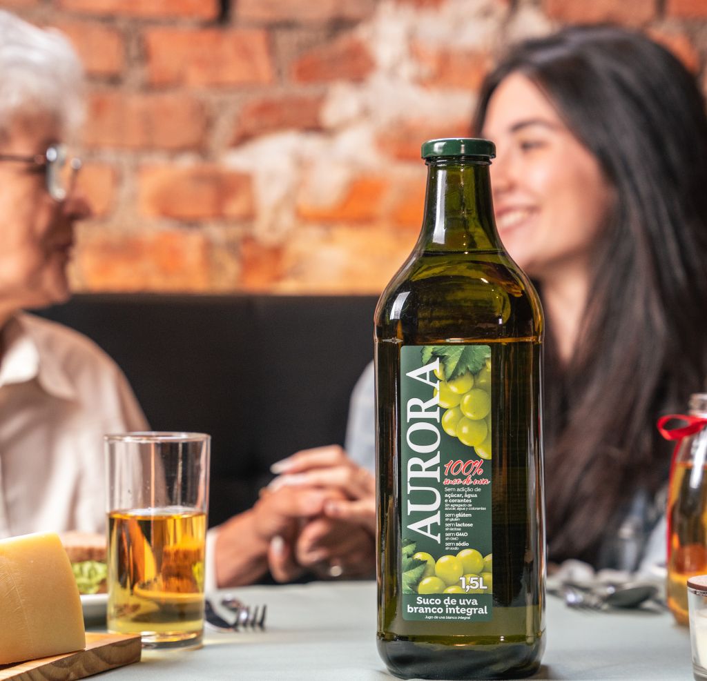 Família fazendo refeição e tomando suco de uva aurora