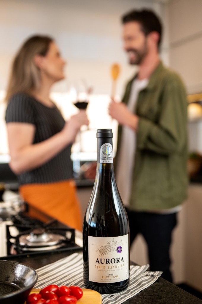 casal tomando o vinho pinot noir aurora pinto bandeira enquanto preparam uma refeição