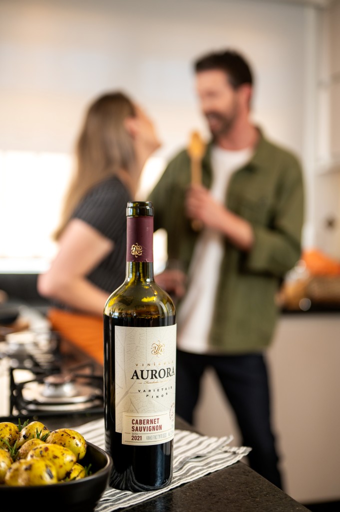 casal preparando jantar romântico com vinho aurora