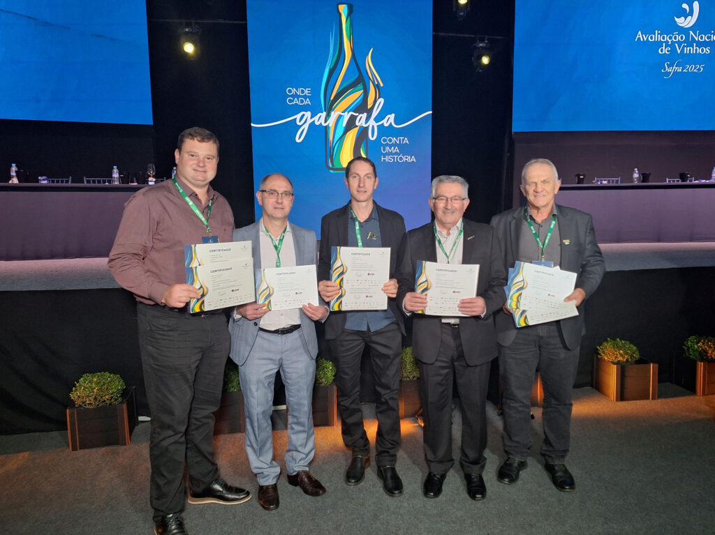 Grupo de cinco homens segurando certificados durante evento da Avaliação Nacional de Vinhos 2025.