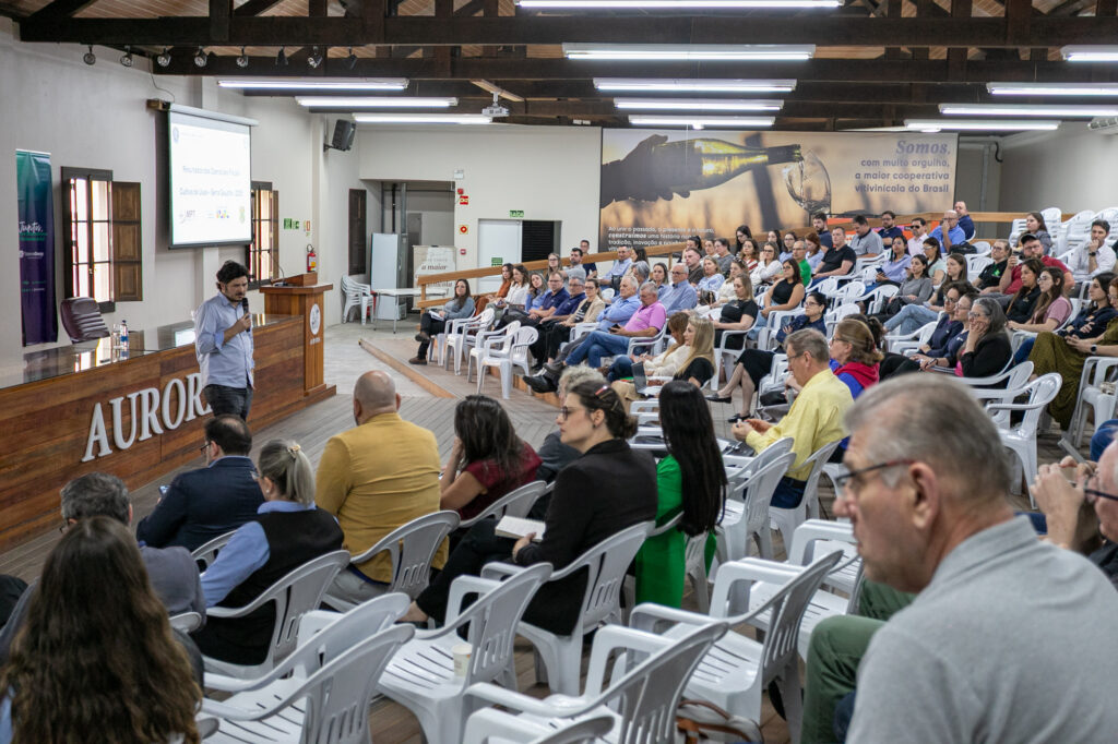 Palestrante apresenta resultados para um auditório cheio na Cooperativa Vinícola Aurora.
