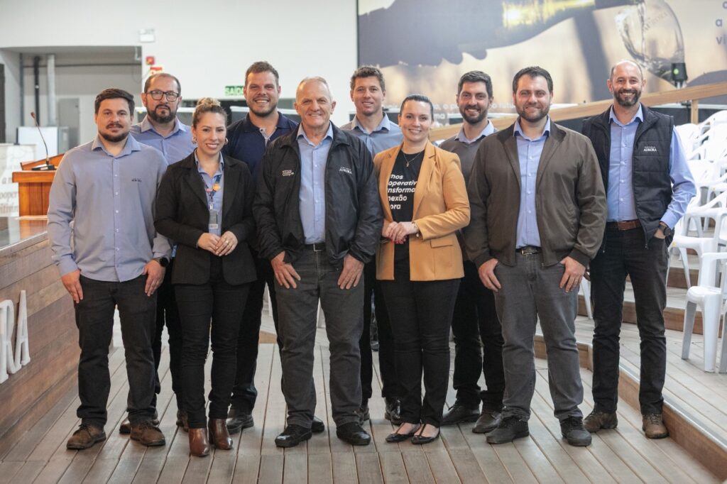 Grupo de profissionais reunidos para foto institucional na sede da Cooperativa Vinícola Aurora.